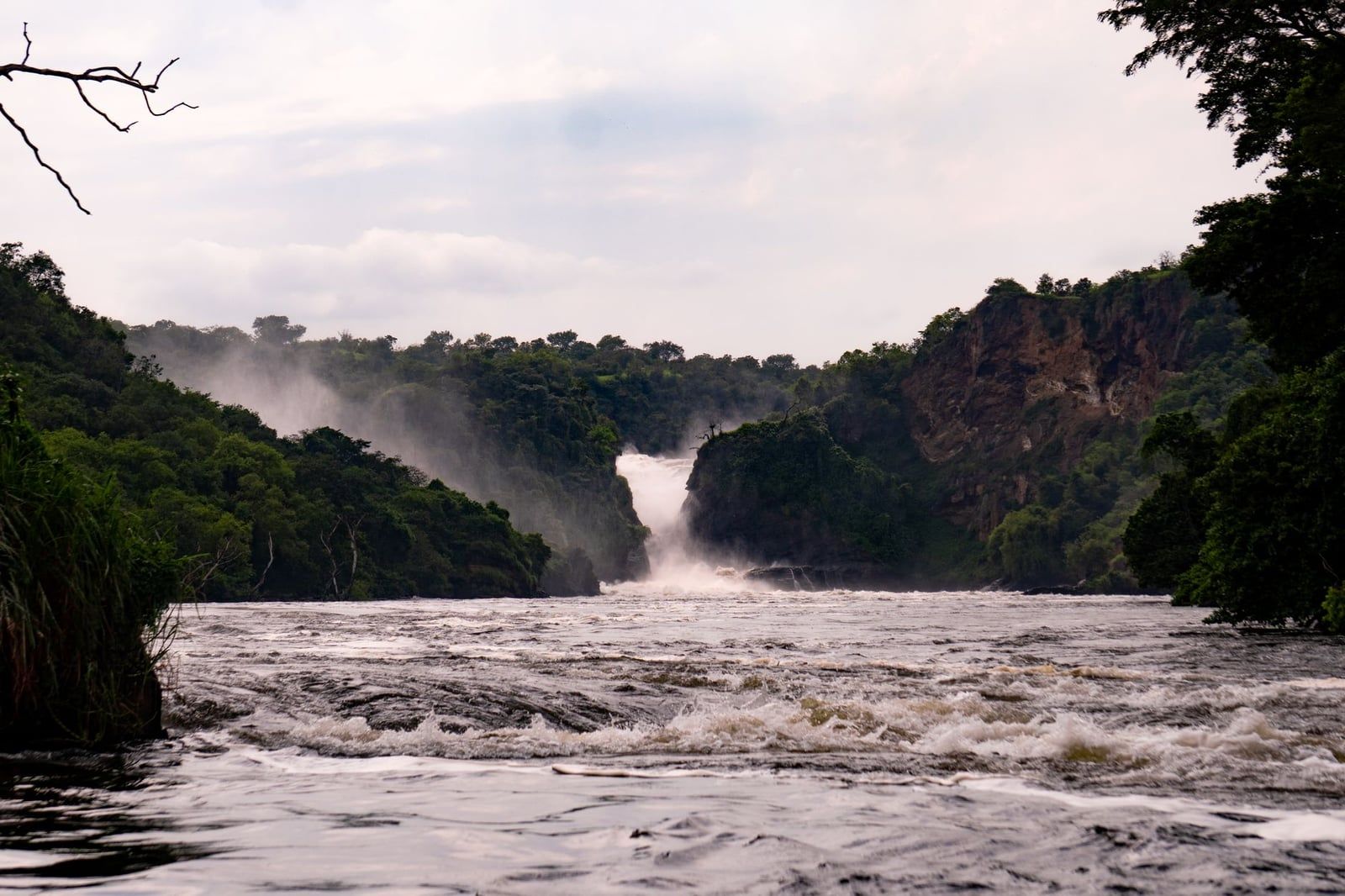 Die wirbelnden Wasser des Victoria-Nil fließen von den Murchison Falls zwischen bewaldeten Klippen im Murchison-Falls-Nationalpark.